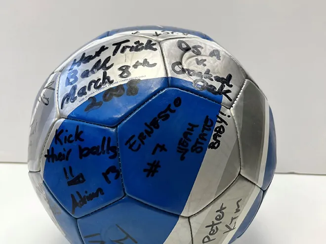 Blue and silver soccer ball with signatures on it