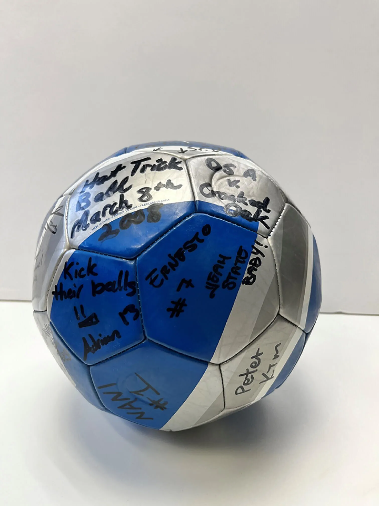 Blue and silver soccer ball with signatures on it